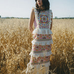 girl in field wearing embroidered colourful maxi dress