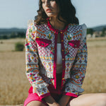 girl wears embroidered colourful jacket with frill