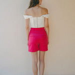 back of white crop top and bright pink shorts