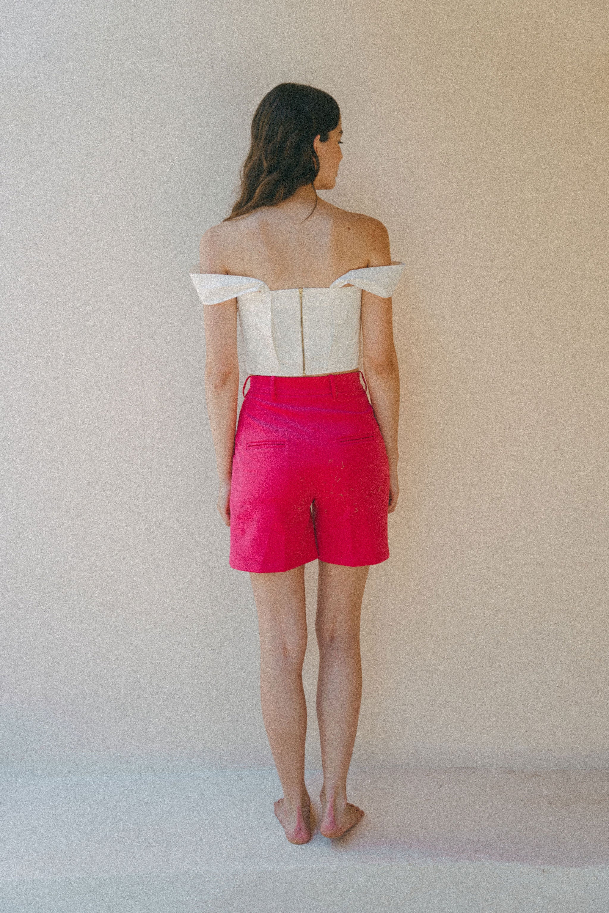 back of white crop top and bright pink shorts