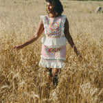 girl in field wearing an embroidered colourful frill top and skirt