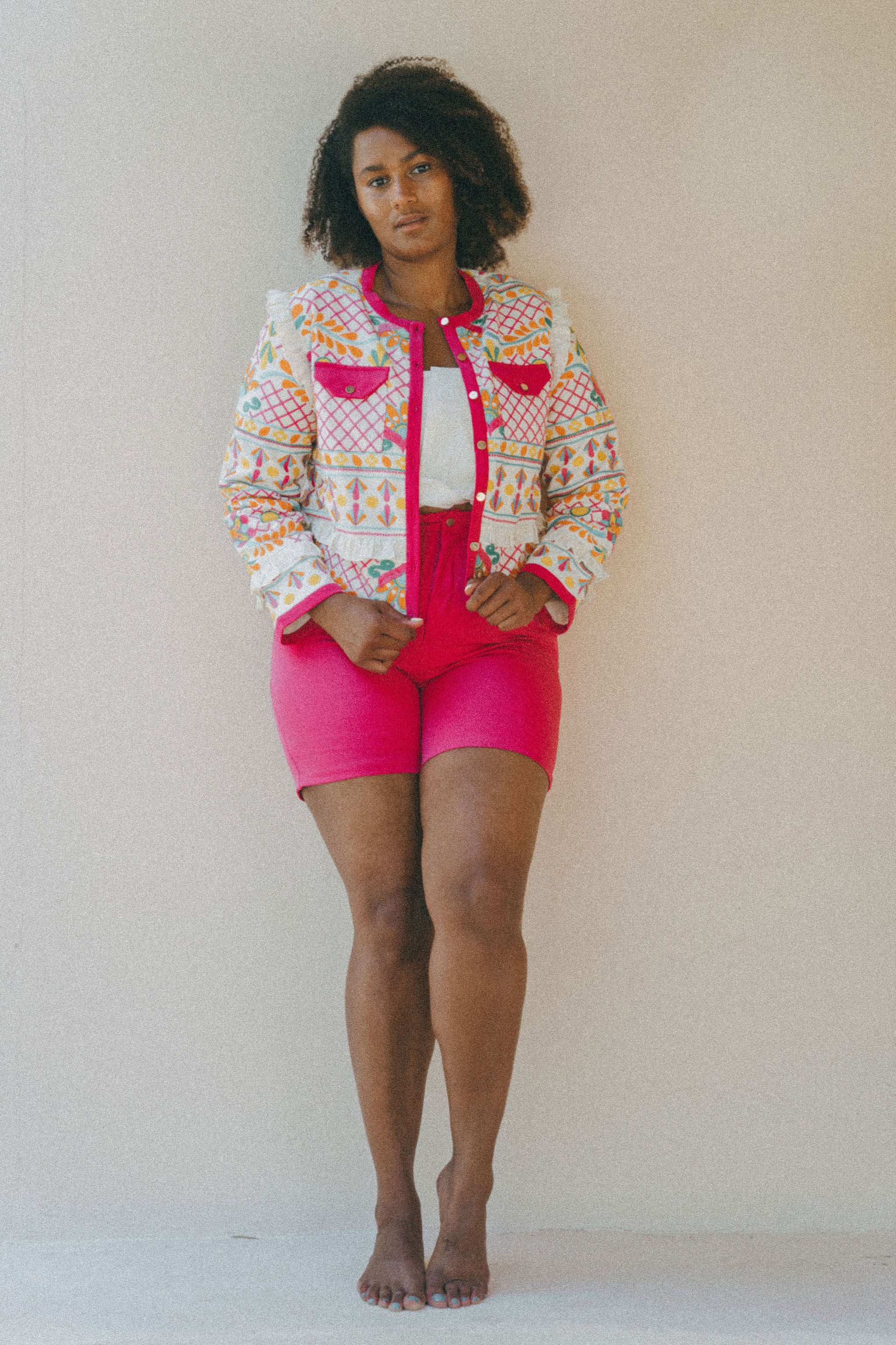 bright pink shorts and embroidered jacket