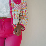 close up of bright pink shorts and embroidered jacket