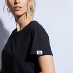 Close up of black organic cotton t-shirt and logo patch on sleeve