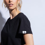Close up of black organic cotton t-shirt and logo patch on sleeve