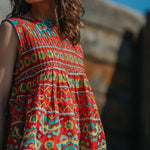 Woman wearing a colorful patterned dress with a blurred background