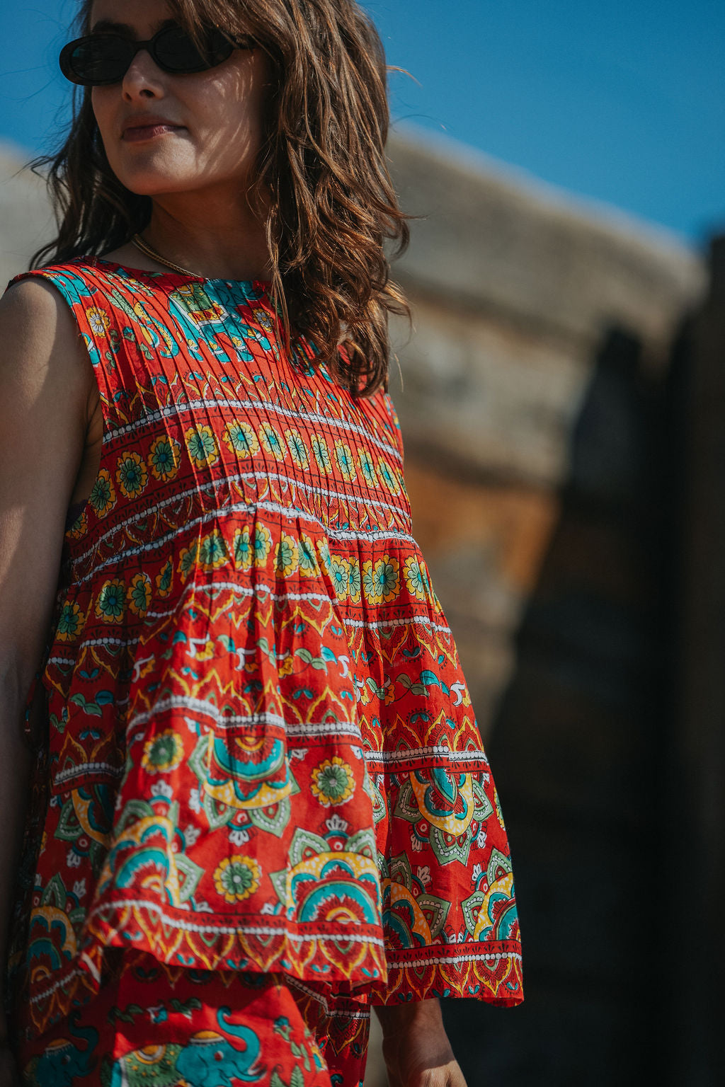 Woman wearing a colorful patterned dress with a blurred background