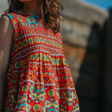 Woman wearing a colorful patterned dress with a blurred background
