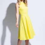 Model wears yellow racer back dress with flared skirt
