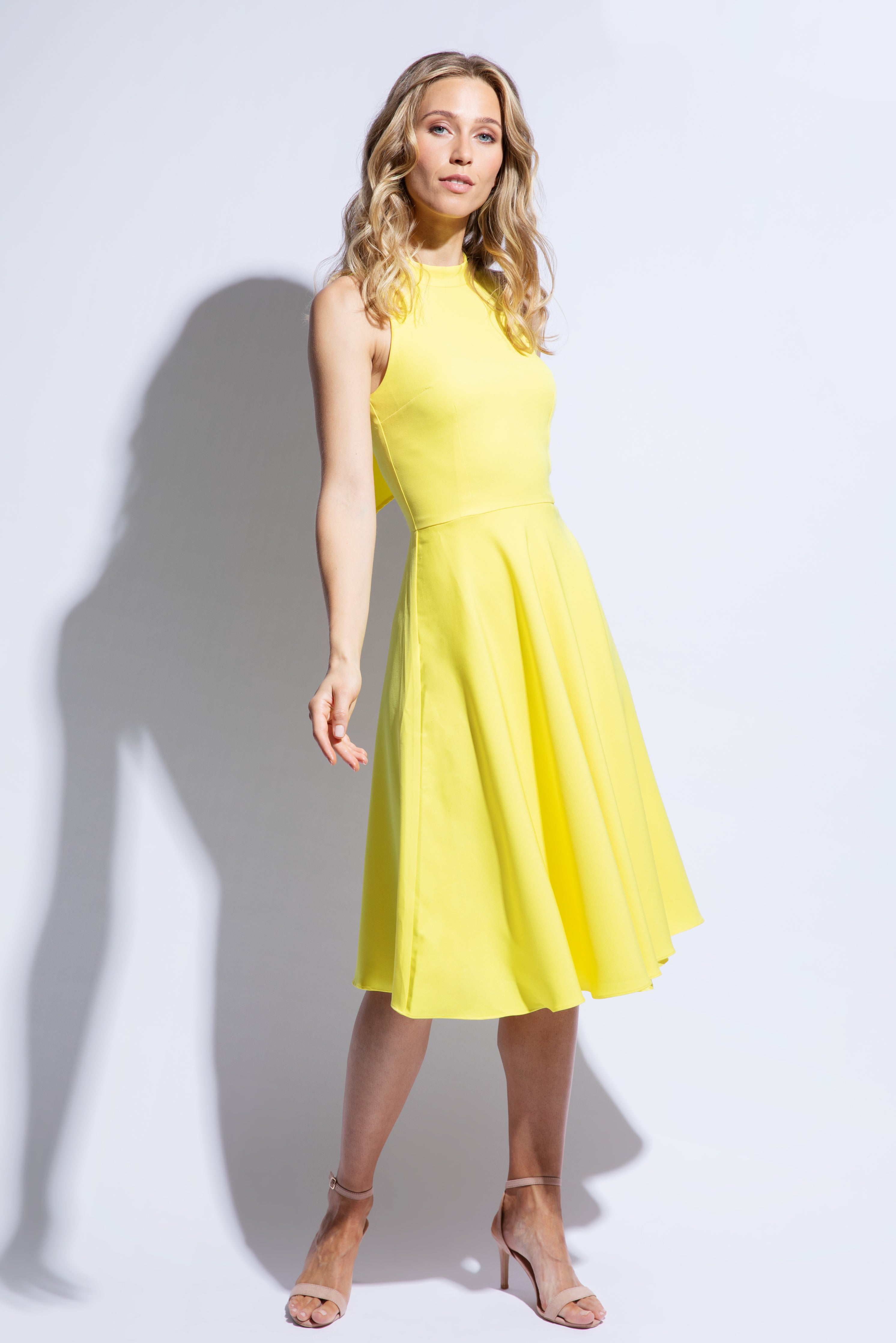 Model wears yellow racer back dress with flared skirt