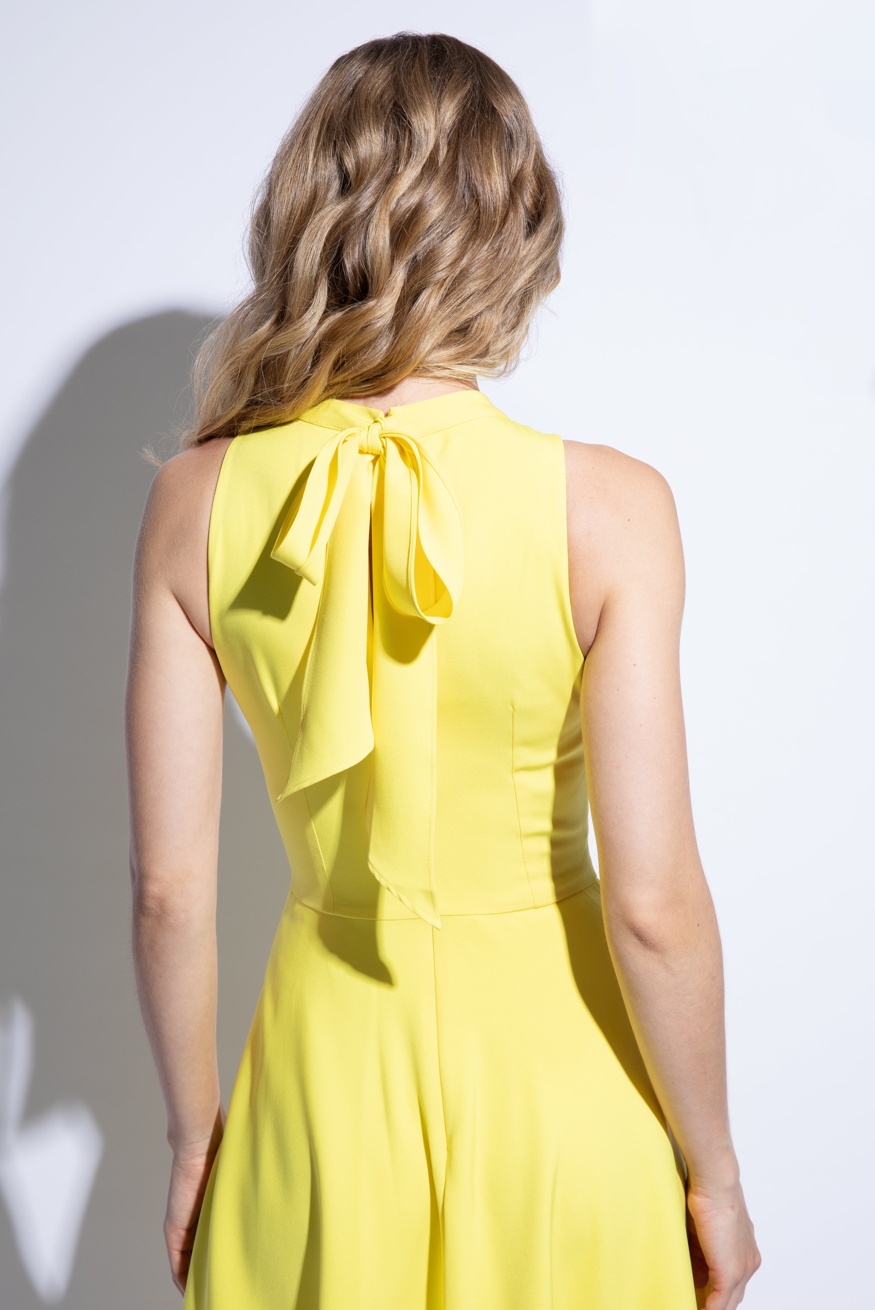 Back detailed view of yellow racer back summer dress with bow detail