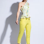 Model wears embroidered one shoulder top and tailored bright yellow trousers