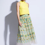 Model wears a brightly embroidered tulle skirt with yellow sleeveless top