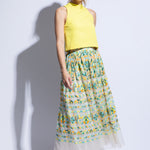 Model wears bright yellow racer back top with embroidered tulle skirt