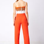 Back view of orange wide leg trouser and beaded bralette with zip detail