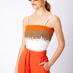 Close up beaded bralette top and orange trouser with pocket and tied belt detail