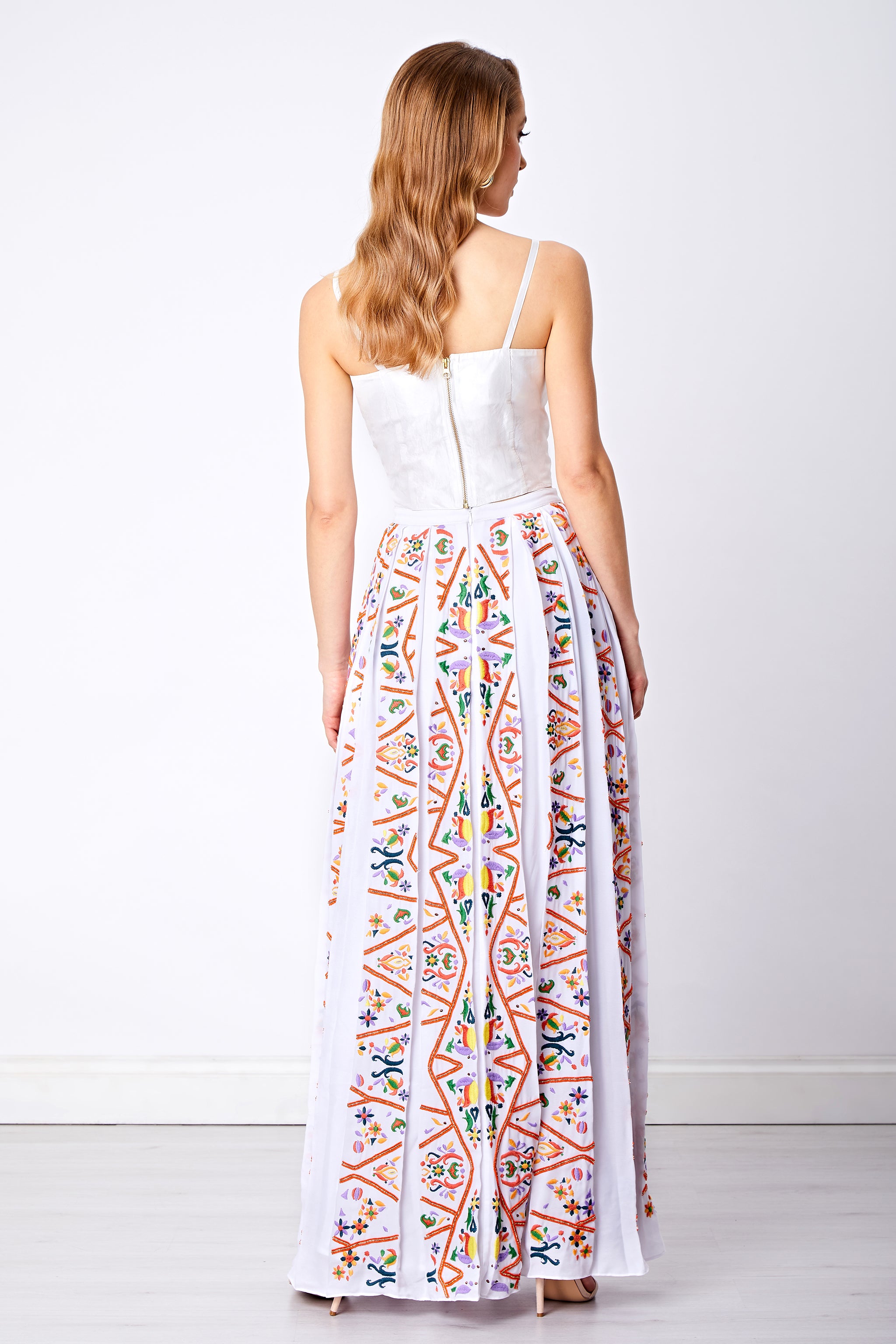 Back view of colorful embellished box pleated maxi skirt and top with zip detail