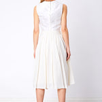 Back view of beaded silk top and white pleated flared skirt