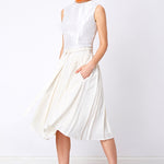 Model wear flared white pleated skirt with sleeveless top