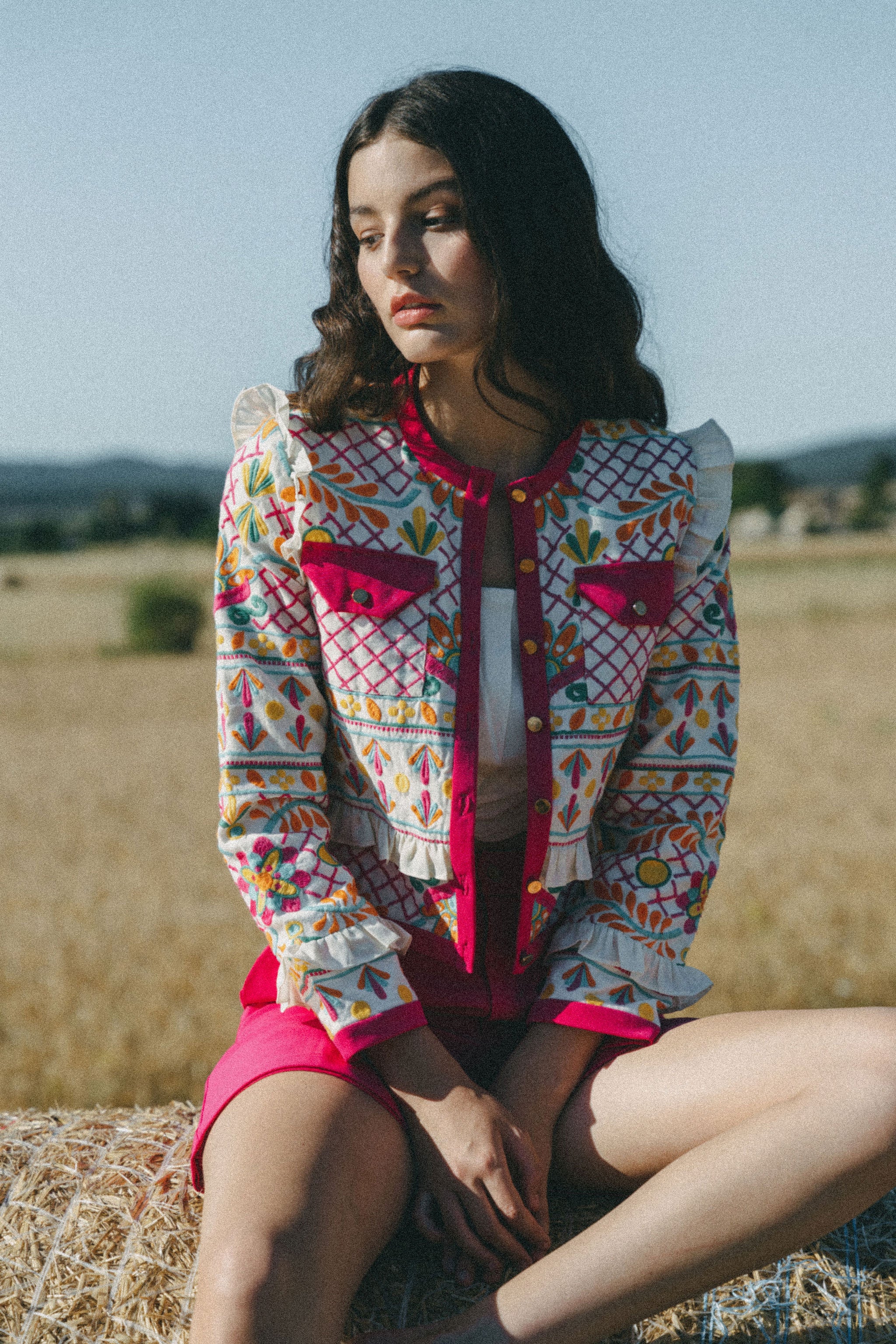 girl wears embroidered colourful jacket with frill