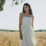 girl in field with white summer flow dress
