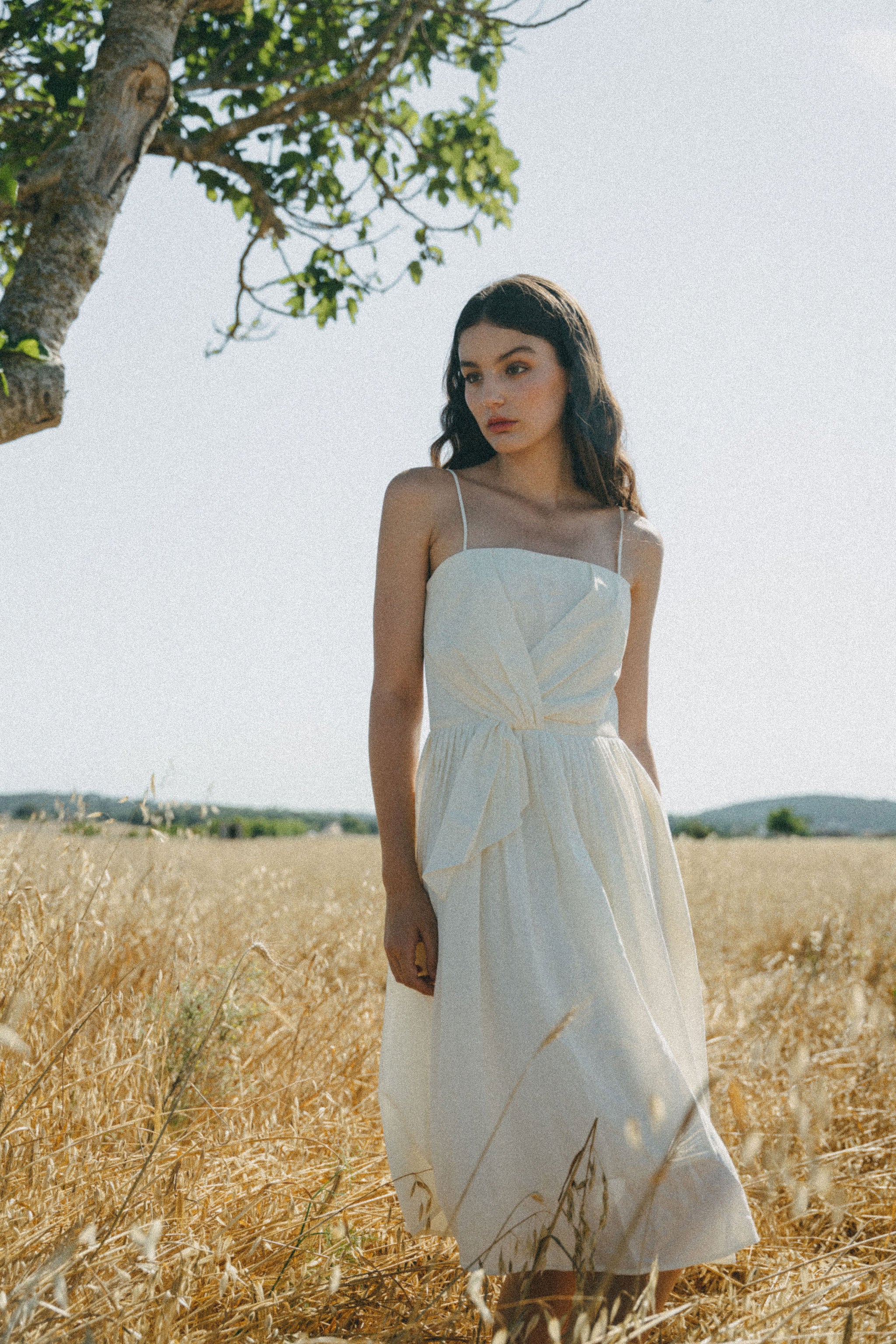 girl in field with white summer flow dress