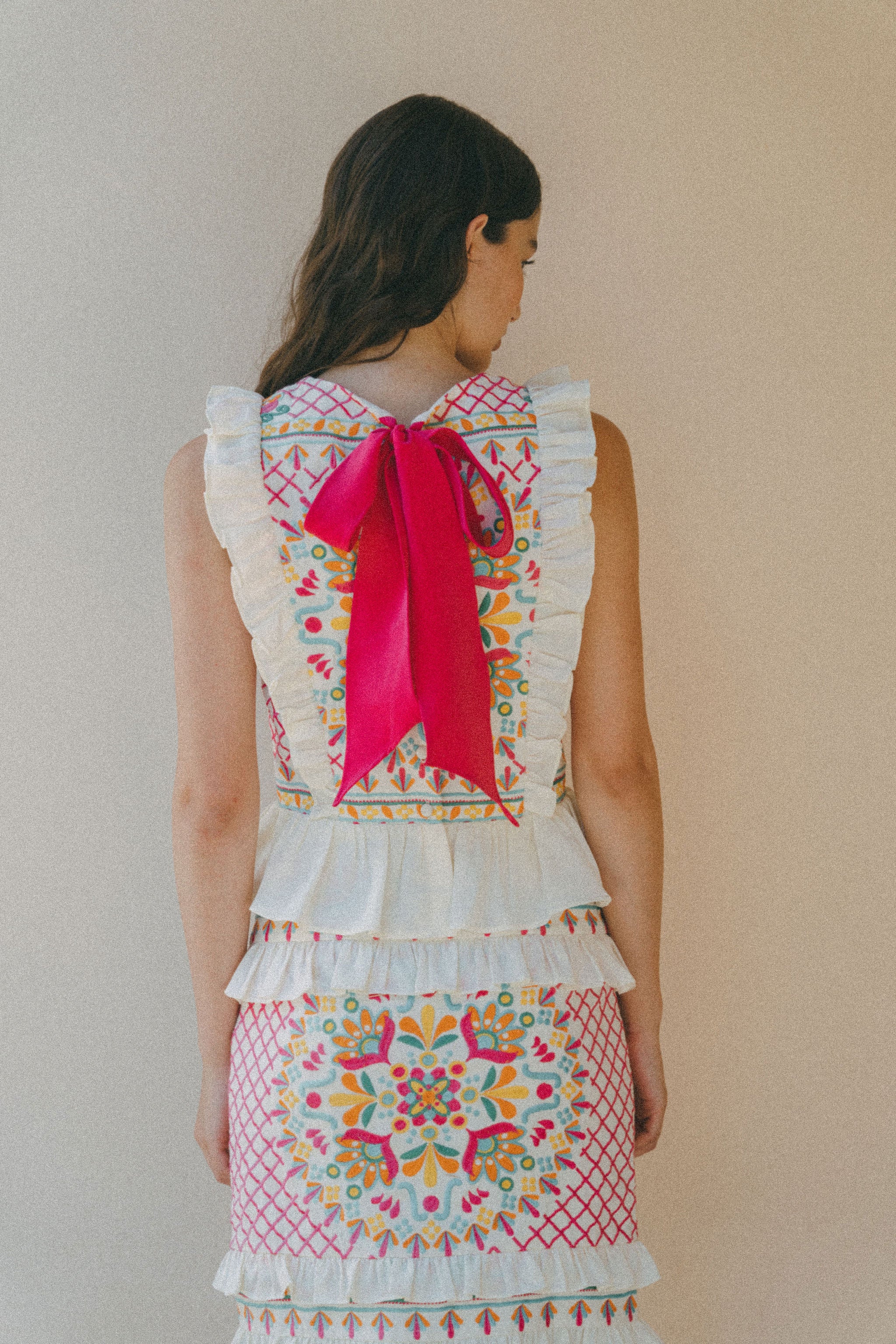 colourful embroidered top and skirt with bright pink bow