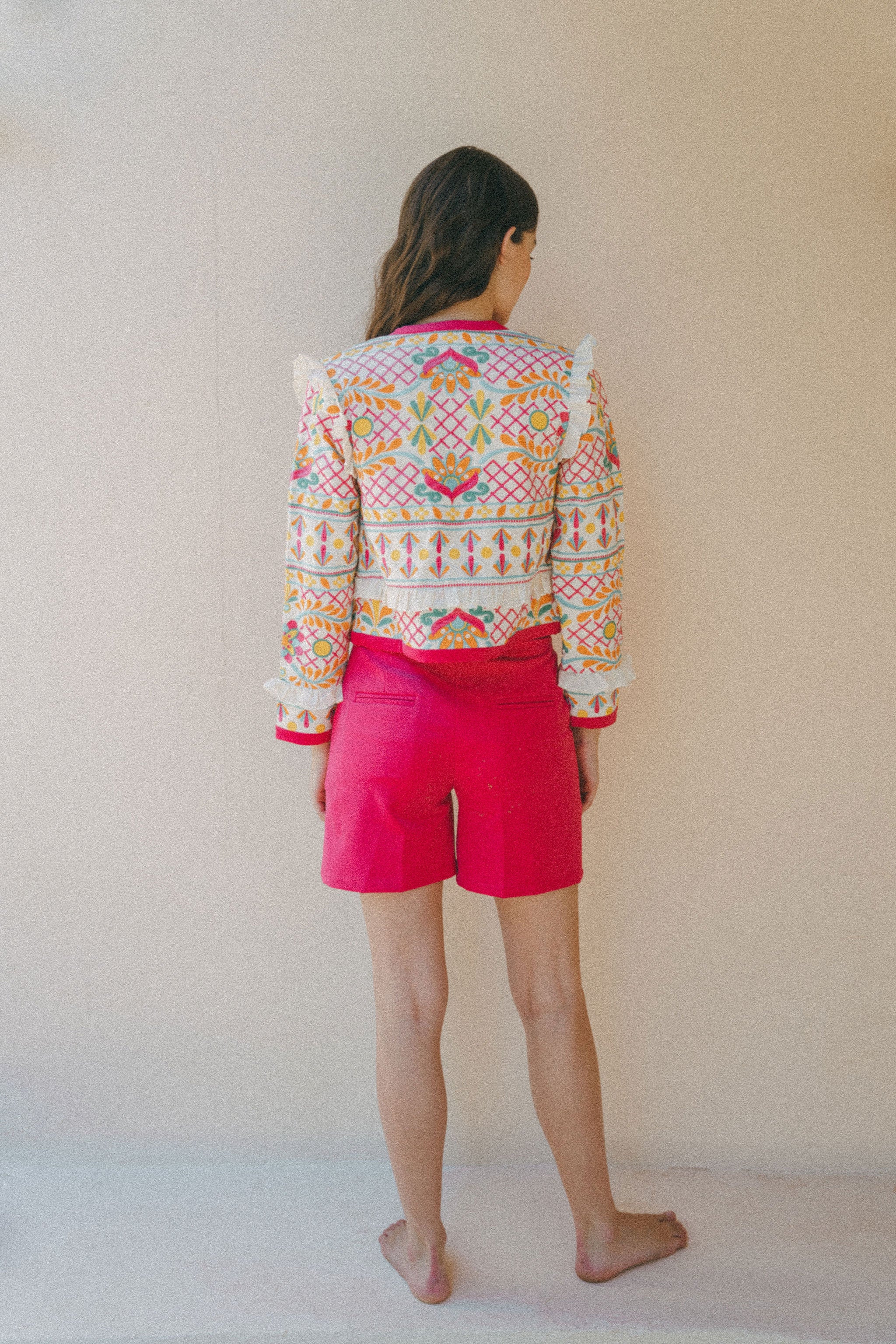 back of colourful embroidered jacket with pink shorts