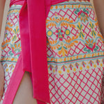 close up of embroidered sarong and pink bow to tie