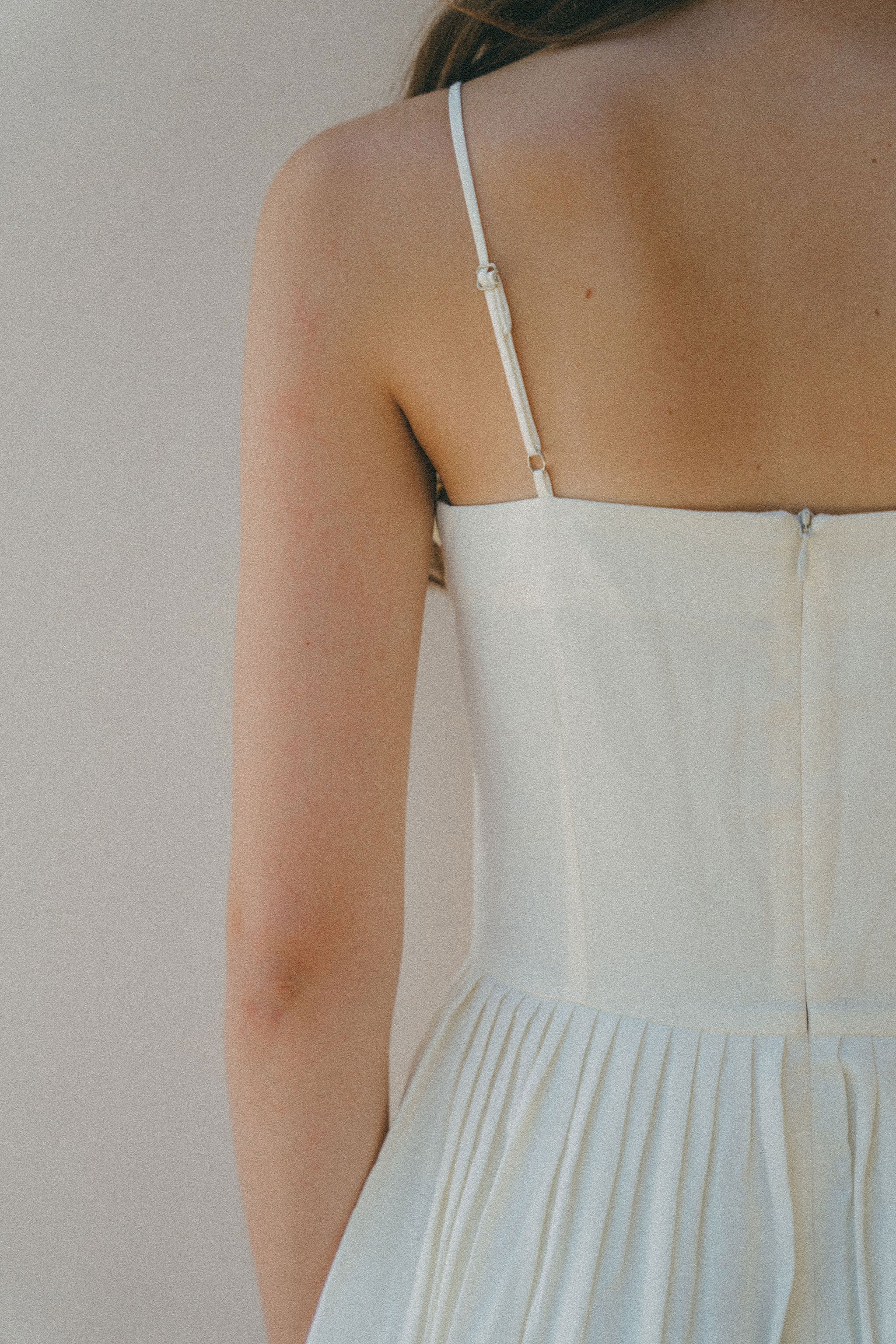 close up of back white dress with thin strap