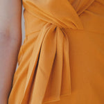 orange fitted dress with pleating details