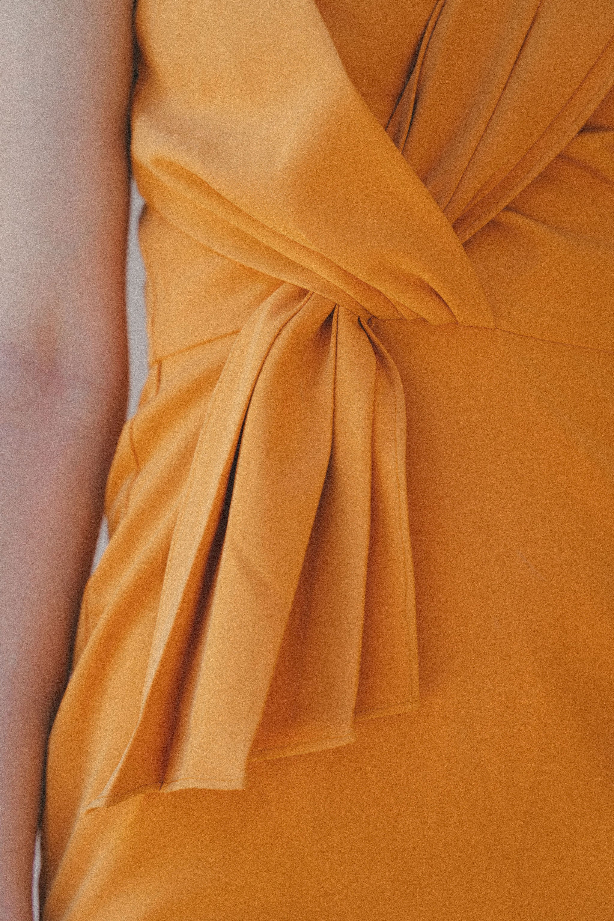 orange fitted dress with pleating details