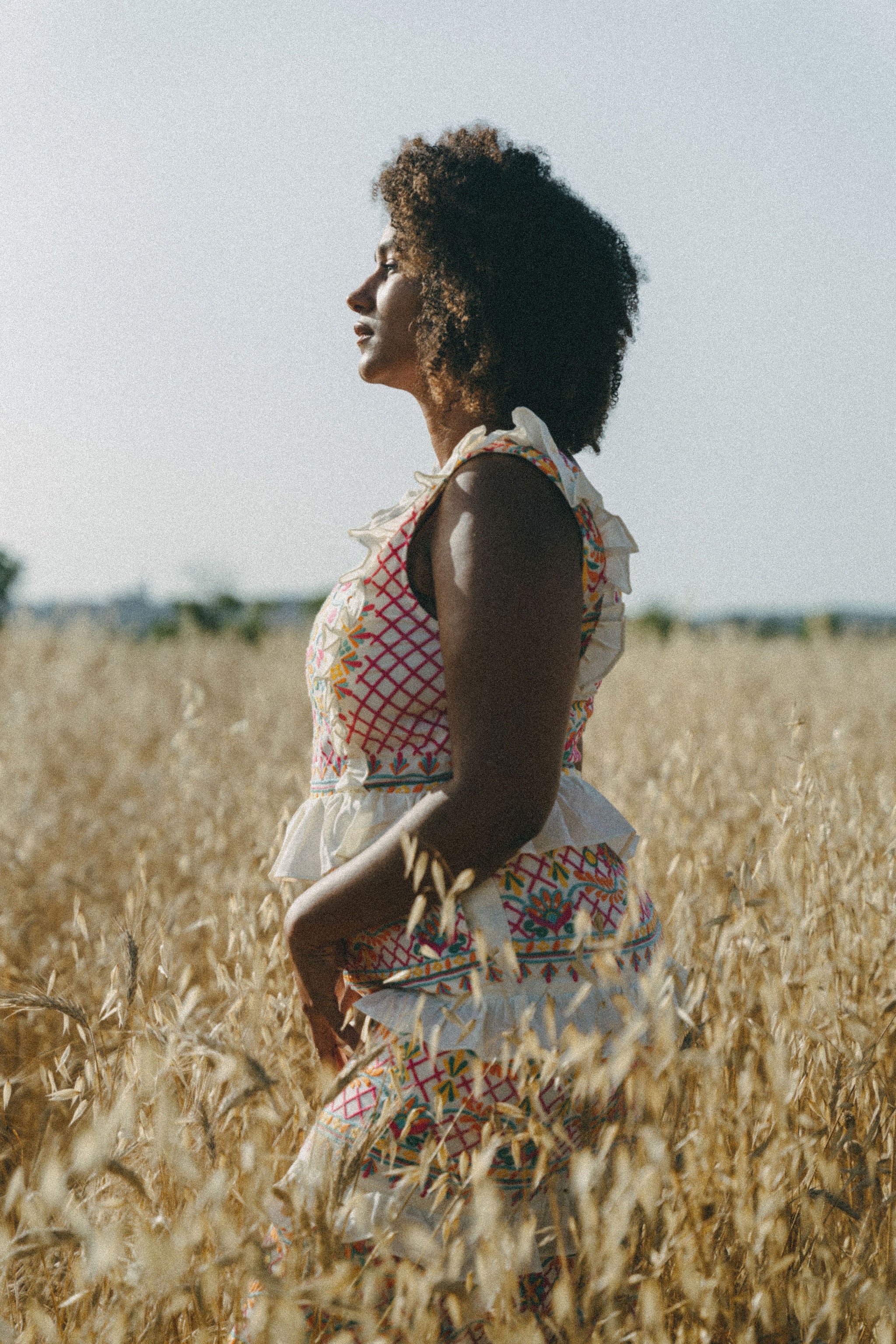 girl in field wearing colourful embroidered maxi dress