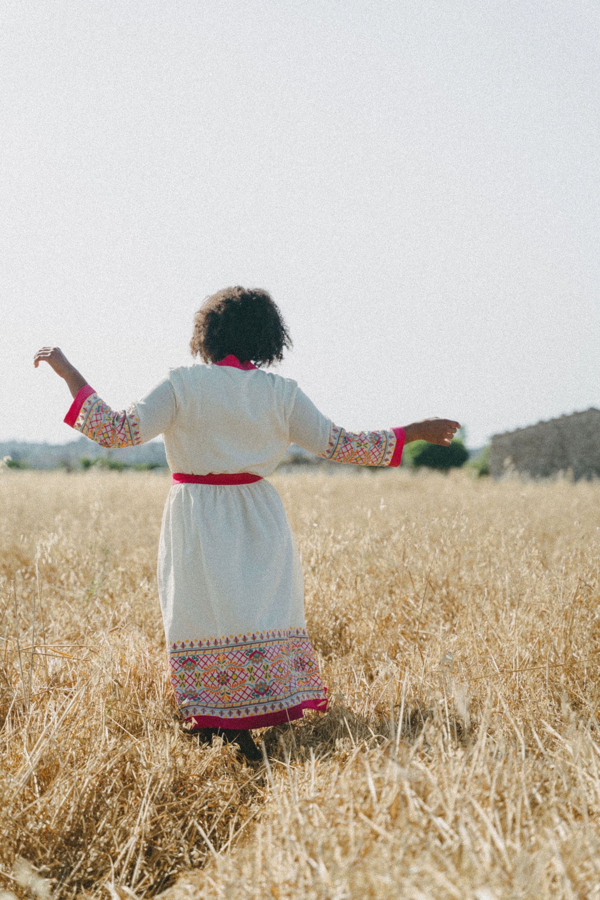 back of white coverup with embroidery and pink belt