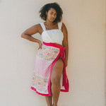 white crop top and colourful embroidered sarong with pink border