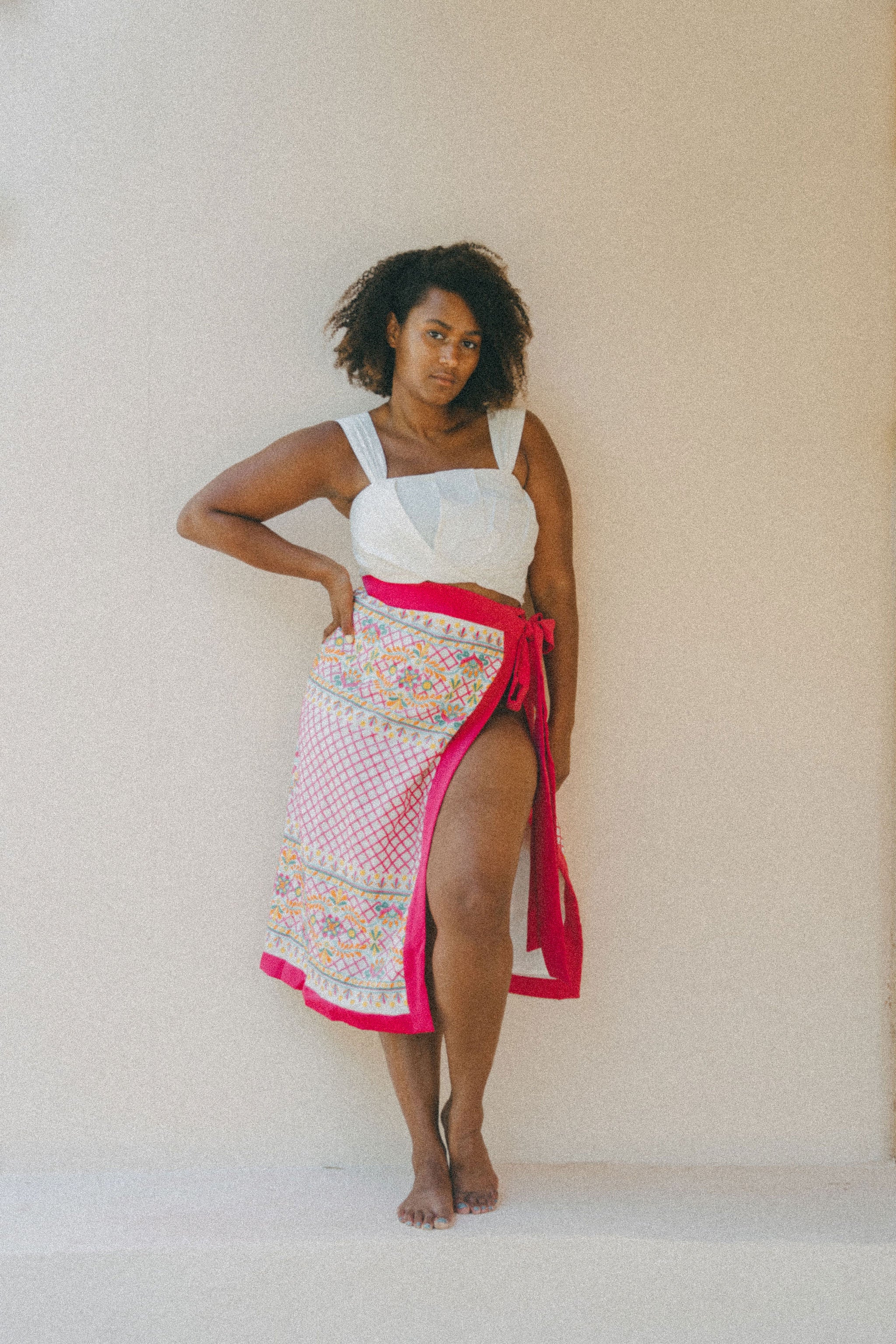 white crop top and colourful embroidered sarong with pink border