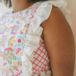 close up of colourful embroidered top with frills