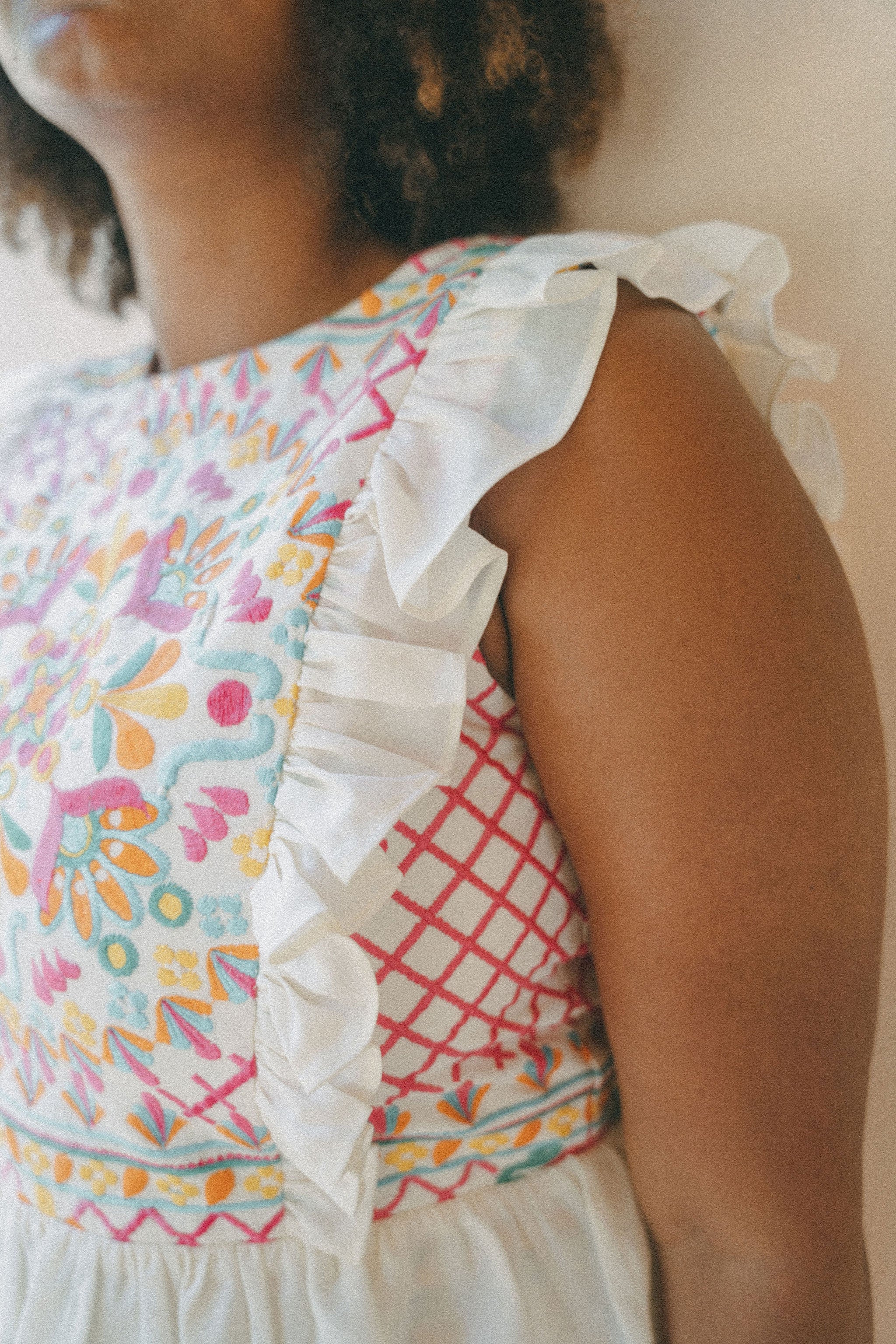 close up of colourful embroidered top with frills