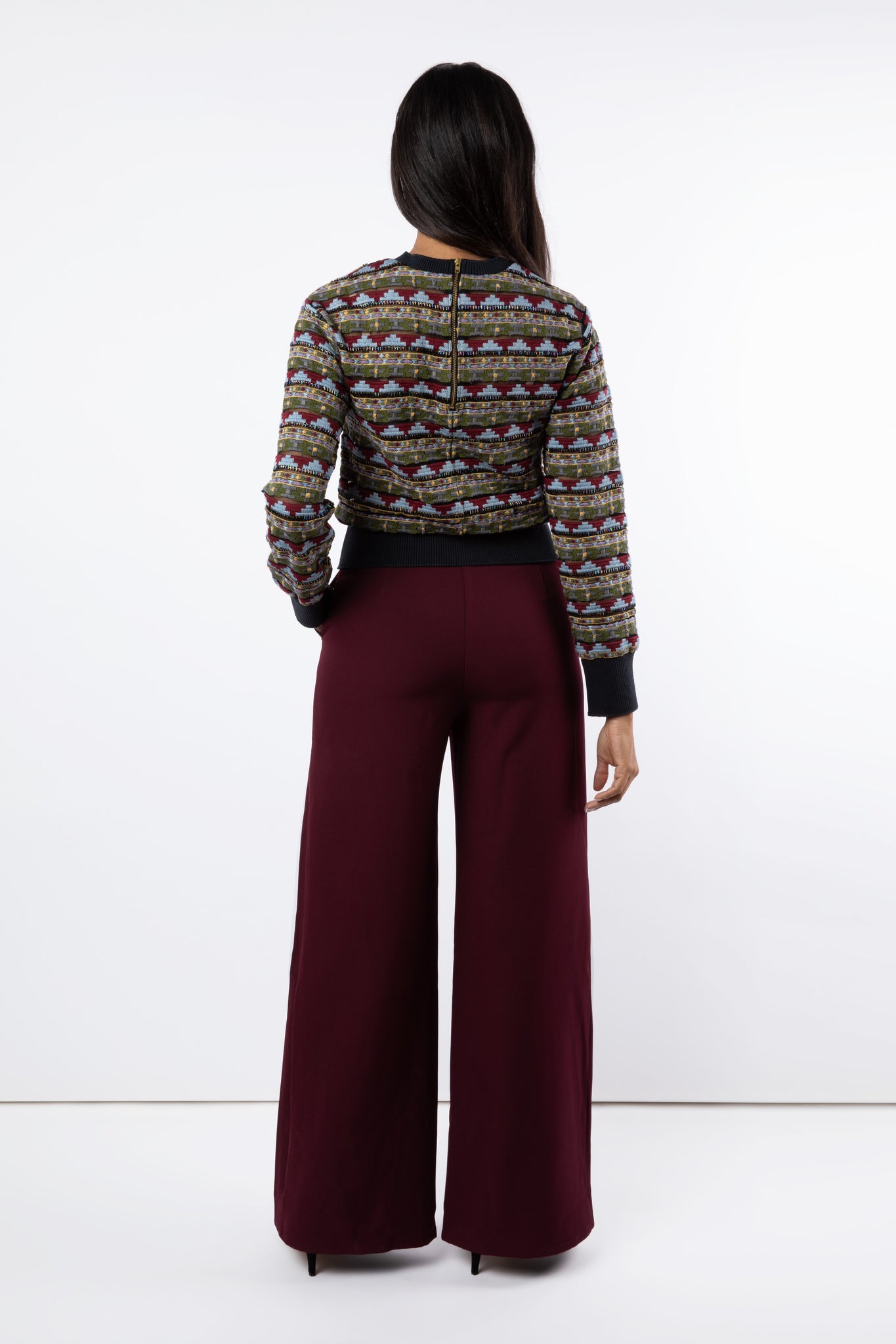 Back view of maroon wide leg trousers and tulle embroidered jumper