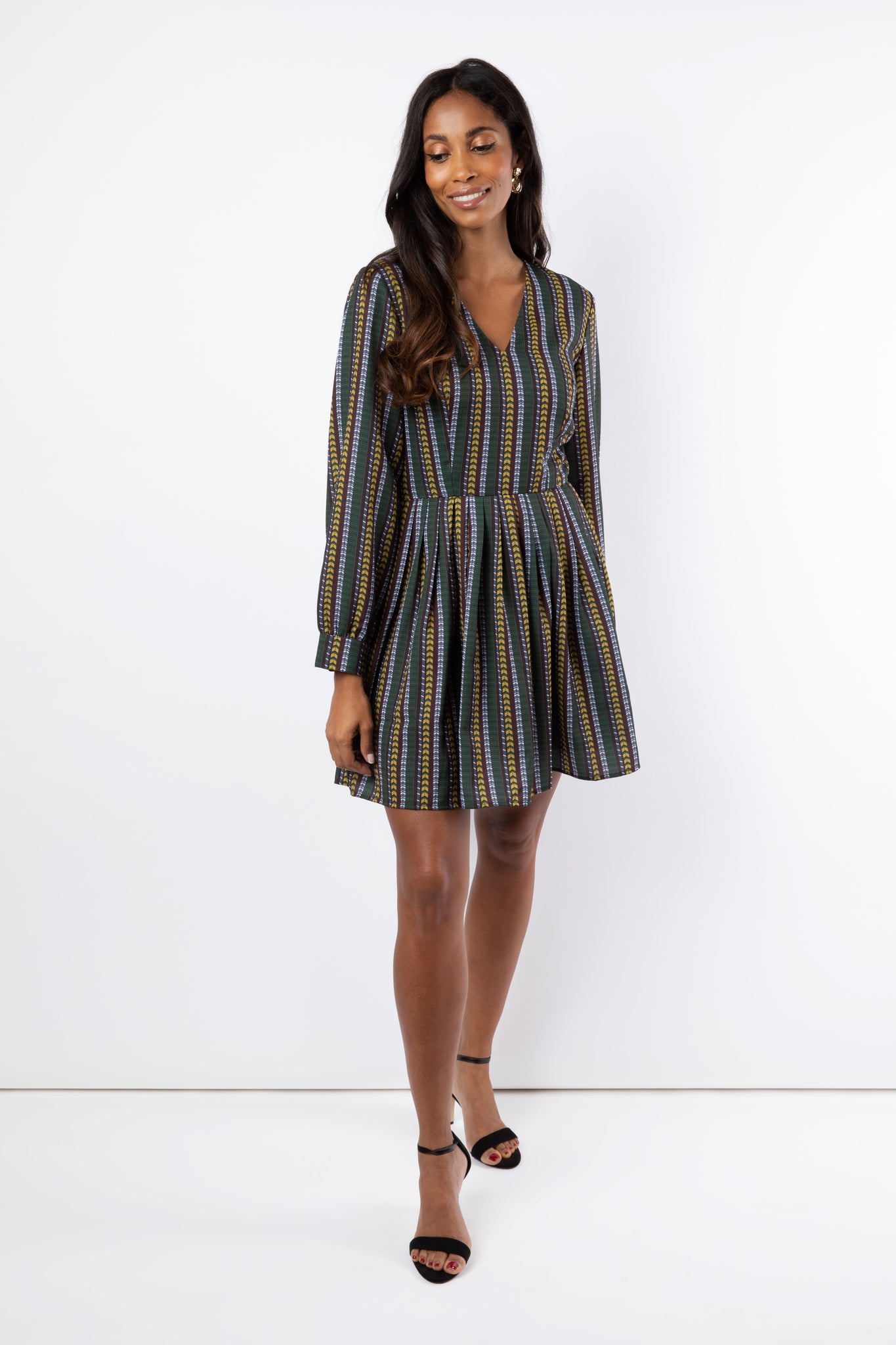 Model wears short geometric printed dress with sleeves