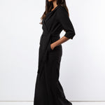 Model wears black jumpsuit with wide leg trouser