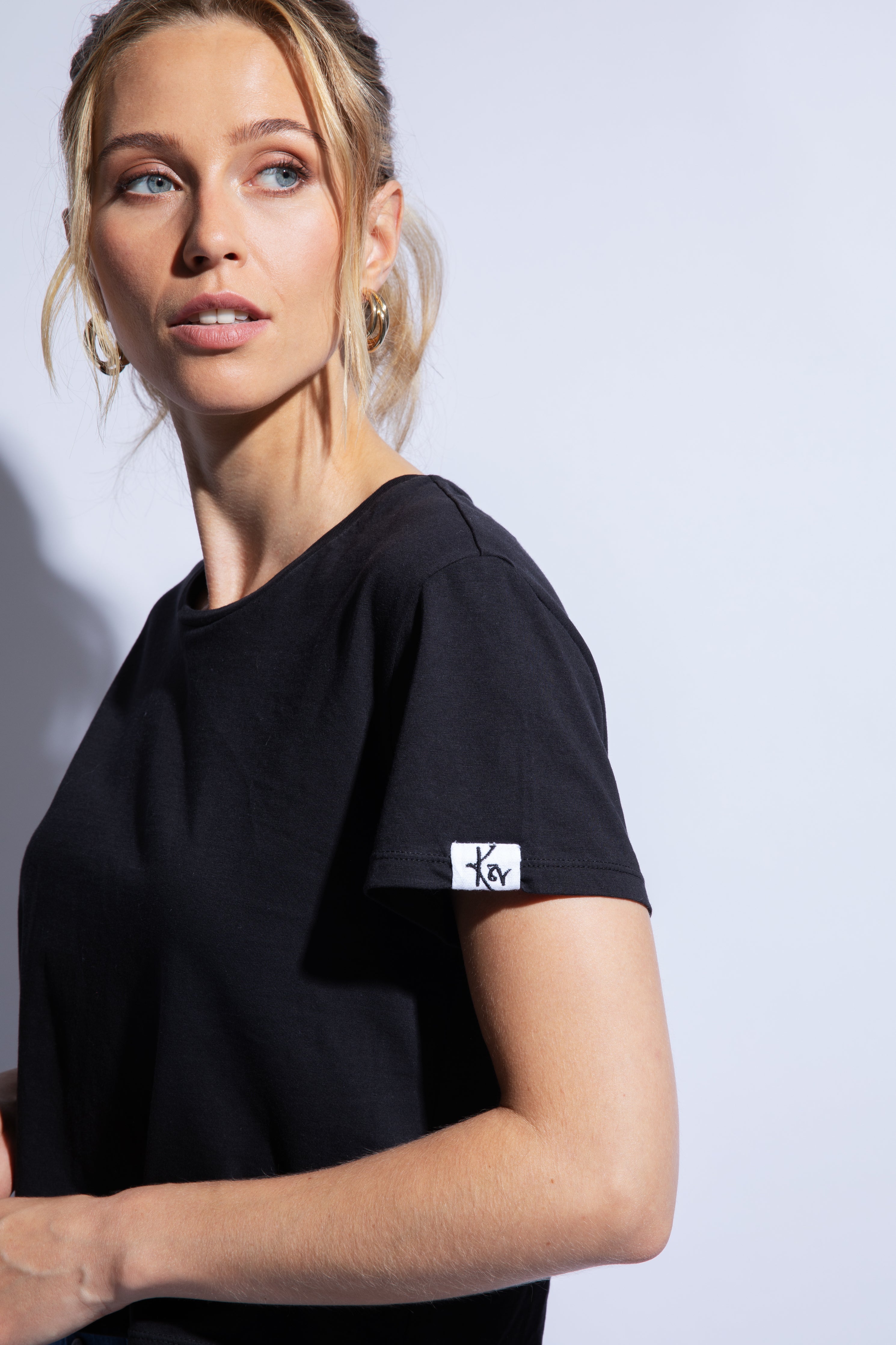 Close up of black organic cotton t-shirt and logo patch on sleeve