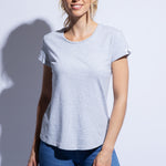 Model wears grey fitted organic cotton t-shirt with rounded hem and jeans
