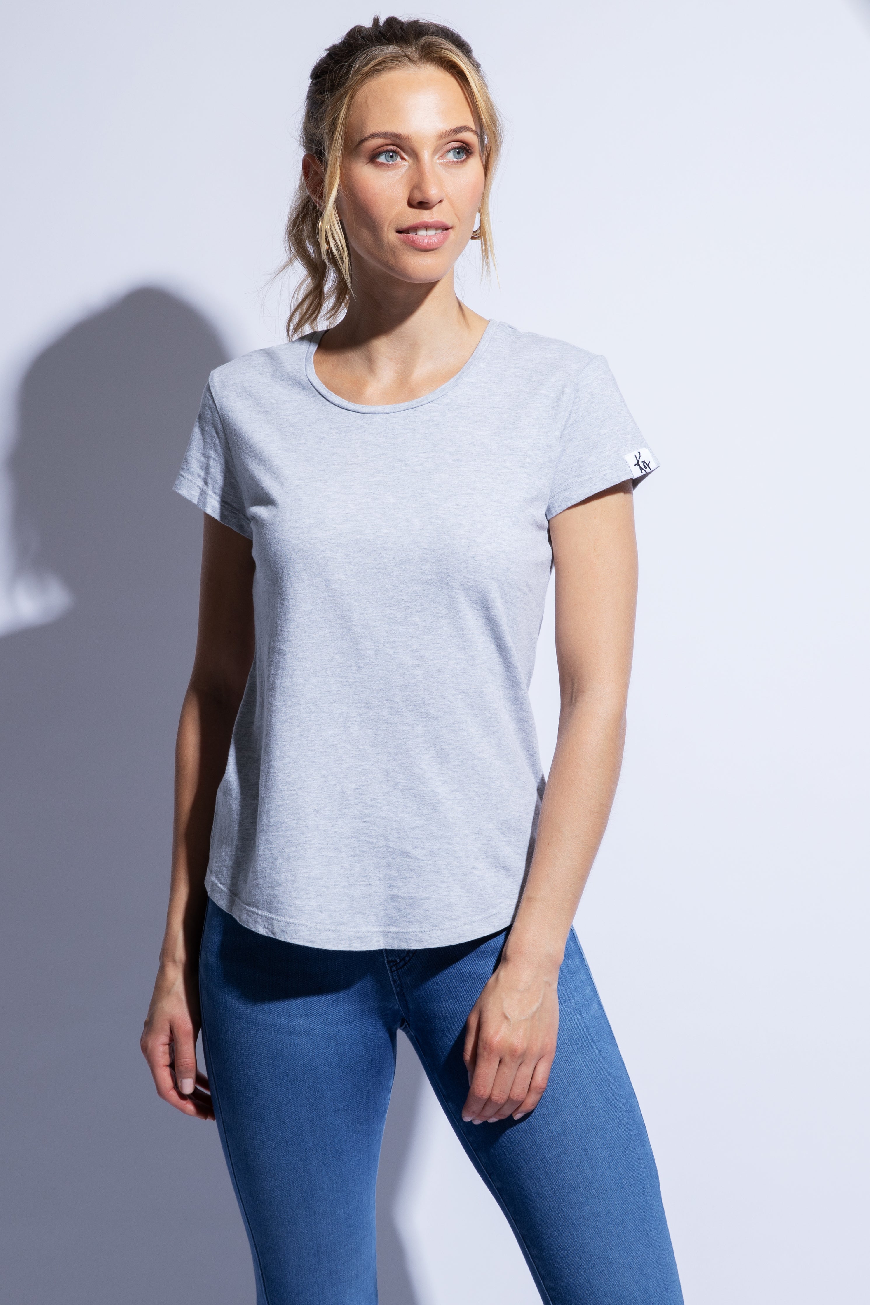 Model wears grey fitted organic cotton t-shirt with rounded hem